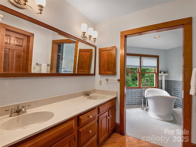 599 Red Fox Ln, Flat Rock, NC 28731 - full bath featuring double vanity, a freestanding tub, wood finished floors, tile walls, and wainscoting