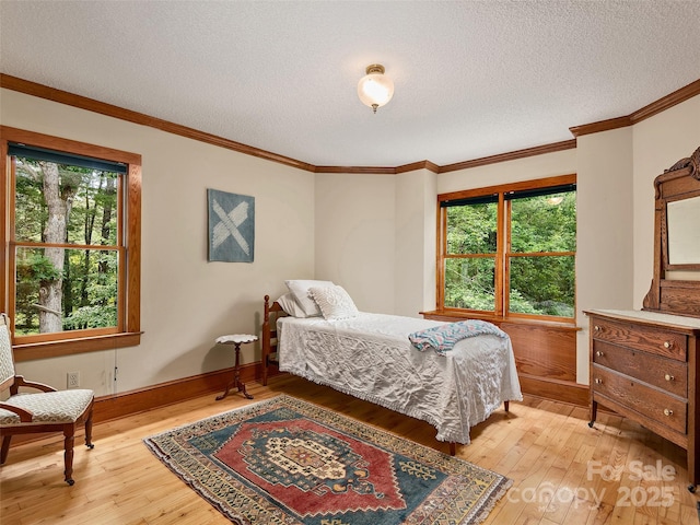 599 Red Fox Ln, Flat Rock, NC 28731 - bedroom with light wood-type flooring, a textured ceiling, and ornamental molding
