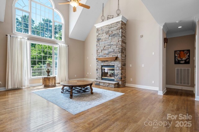 2301 Willow Creek Dr, Newton, NC 28658 - living room featuring a towering ceiling, wood finished floors, a ceiling fan, and a stone fireplace