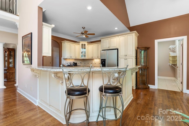 2301 Willow Creek Dr, Newton, NC 28658 - kitchen with stainless steel fridge with ice dispenser, cream cabinetry, a peninsula, ceiling fan, and a kitchen breakfast bar