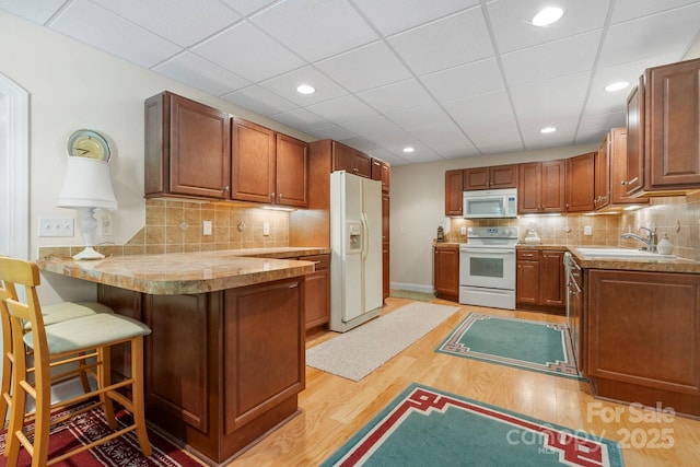 2301 Willow Creek Dr, Newton, NC 28658 - kitchen featuring white appliances, a peninsula, light wood-style floors, tasteful backsplash, and recessed lighting