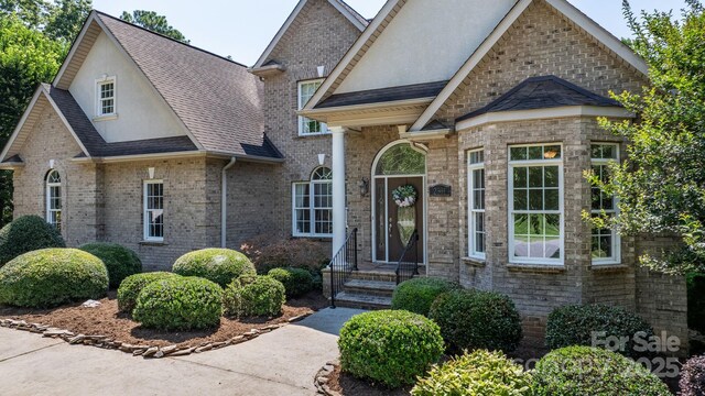 2301 Willow Creek Dr, Newton, NC 28658 - view of front facade featuring roof with shingles, stucco siding, and brick siding
