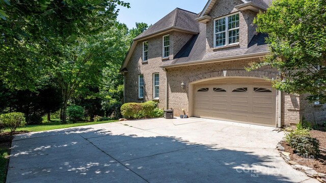 2301 Willow Creek Dr, Newton, NC 28658 - view of front of home with driveway, brick siding, a shingled roof, and an attached garage