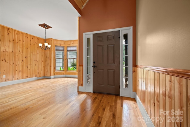 60 Bridge Ln, Tryon, NC 28782 - foyer featuring a chandelier, wood finished floors, wood walls, and a high ceiling