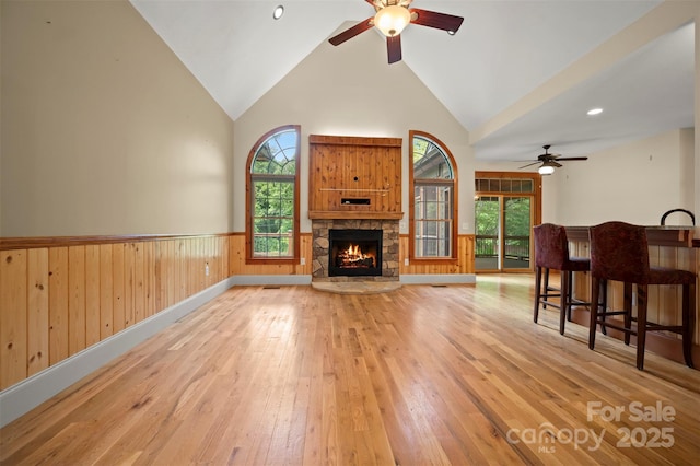 60 Bridge Ln, Tryon, NC 28782 - living room featuring a ceiling fan, a wainscoted wall, light wood-style flooring, high vaulted ceiling, and plenty of natural light