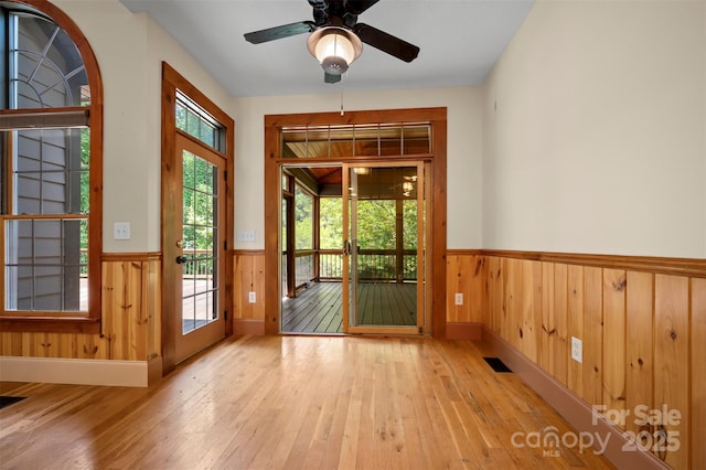 60 Bridge Ln, Tryon, NC 28782 - doorway with wainscoting, wood-type flooring, a ceiling fan, and wooden walls