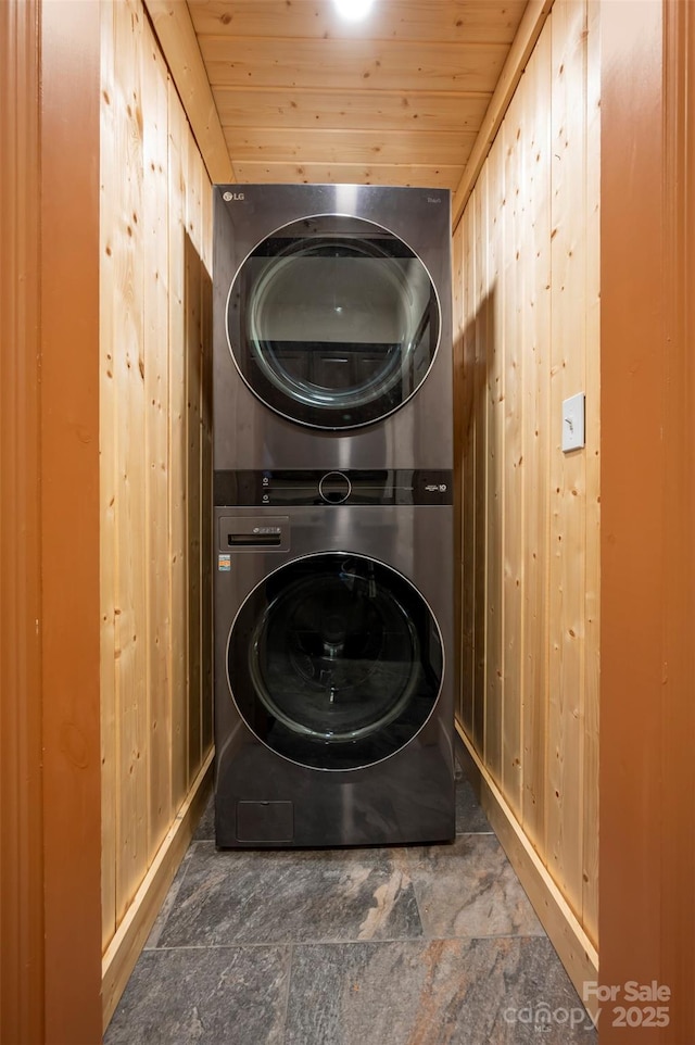 60 Bridge Ln, Tryon, NC 28782 - washroom with stacked washer and clothes dryer, wooden walls, wood ceiling, and stone finish flooring