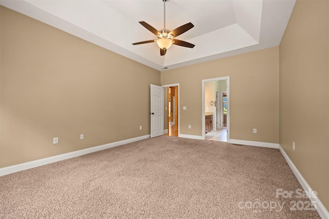 60 Bridge Ln, Tryon, NC 28782 - unfurnished bedroom featuring light colored carpet, ensuite bath, a raised ceiling, and a ceiling fan