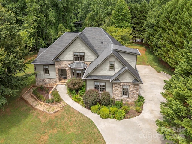 60 Bridge Ln, Tryon, NC 28782 - view of front of house featuring stone siding, a forest view, roof with shingles, and a front lawn