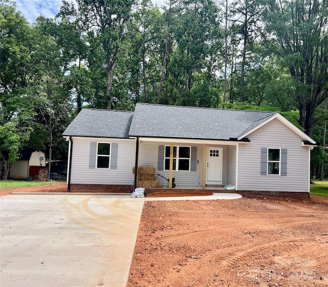 234 W Vance St, China Grove, NC 28023 - single story home featuring covered porch, a storage unit, a shingled roof, and concrete driveway
