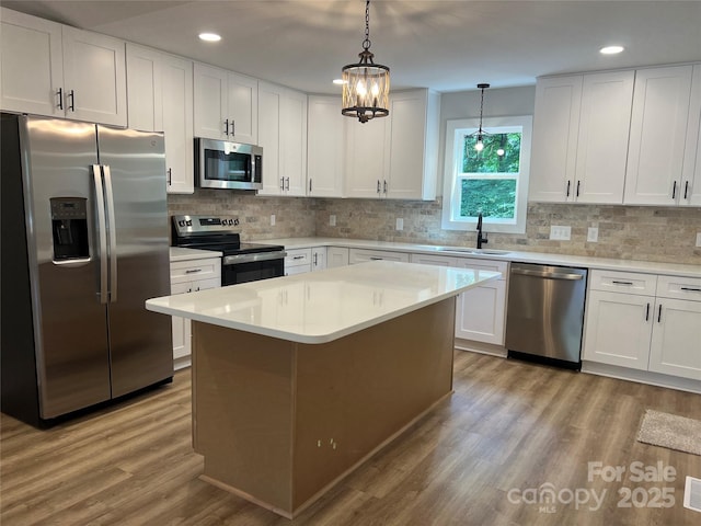 234 W Vance St, China Grove, NC 28023 - kitchen with stainless steel appliances, light wood finished floors, white cabinetry, recessed lighting, and light countertops