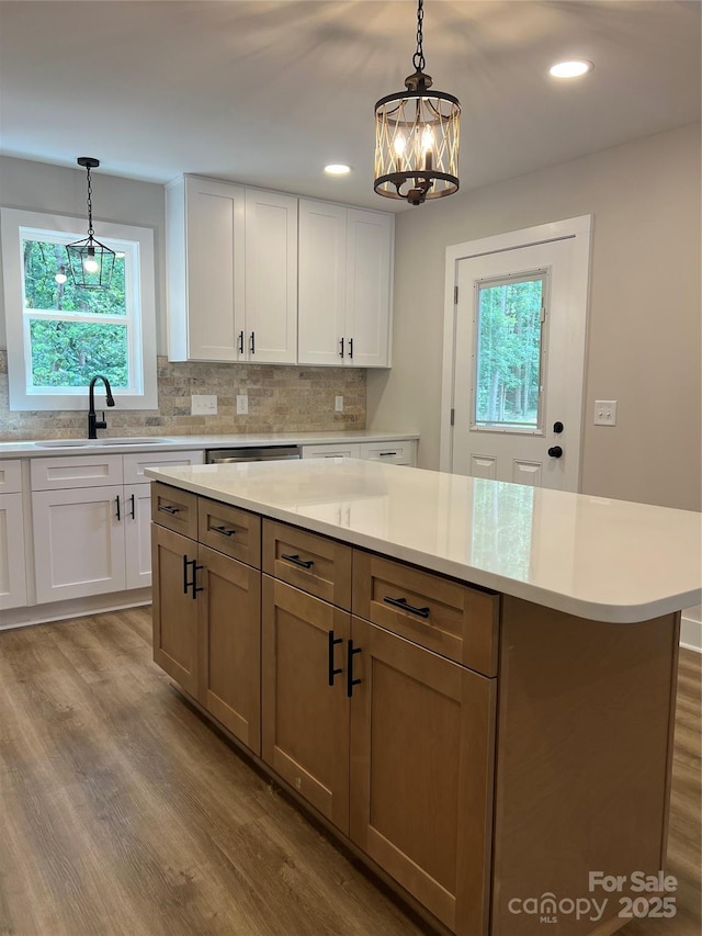 234 W Vance St, China Grove, NC 28023 - kitchen featuring wood finished floors, light countertops, white cabinets, decorative backsplash, and a chandelier