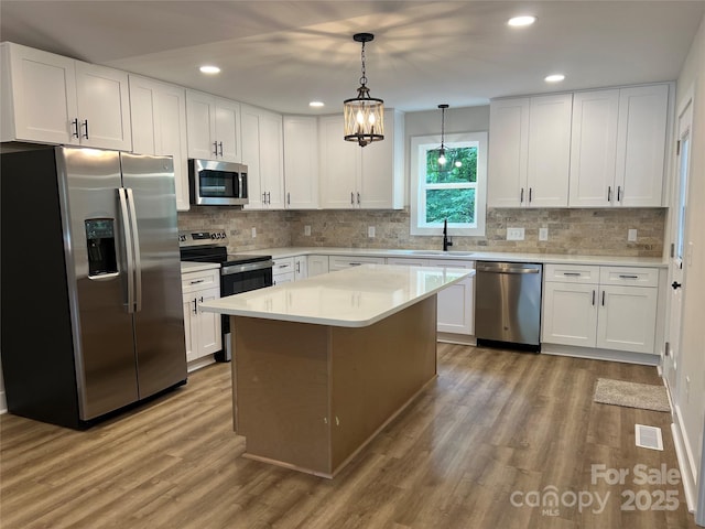 234 W Vance St, China Grove, NC 28023 - kitchen featuring appliances with stainless steel finishes, light wood-style flooring, white cabinetry, recessed lighting, and backsplash