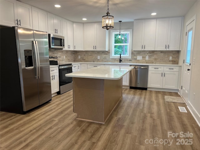 234 W Vance St, China Grove, NC 28023 - kitchen with appliances with stainless steel finishes, wood finished floors, light countertops, white cabinetry, and recessed lighting