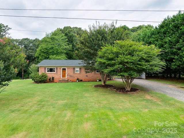 1715 Nelson Dr, Newton, NC 28658 - single story home featuring brick siding, gravel driveway, a front lawn, and a view of trees