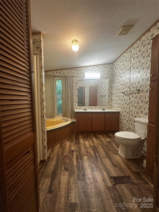 584 Ebenezer Rd, Old Fort, NC 28762 - full bathroom with wood finished floors, a textured ceiling, a garden tub, wallpapered walls, and double vanity