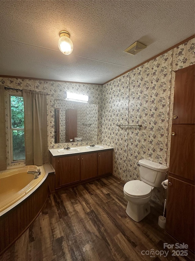 584 Ebenezer Rd, Old Fort, NC 28762 - full bathroom with wood finished floors, a bath, double vanity, a textured ceiling, and wallpapered walls