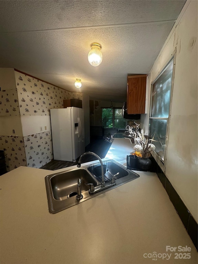 584 Ebenezer Rd, Old Fort, NC 28762 - kitchen with white fridge with ice dispenser, brown cabinets, and a textured ceiling