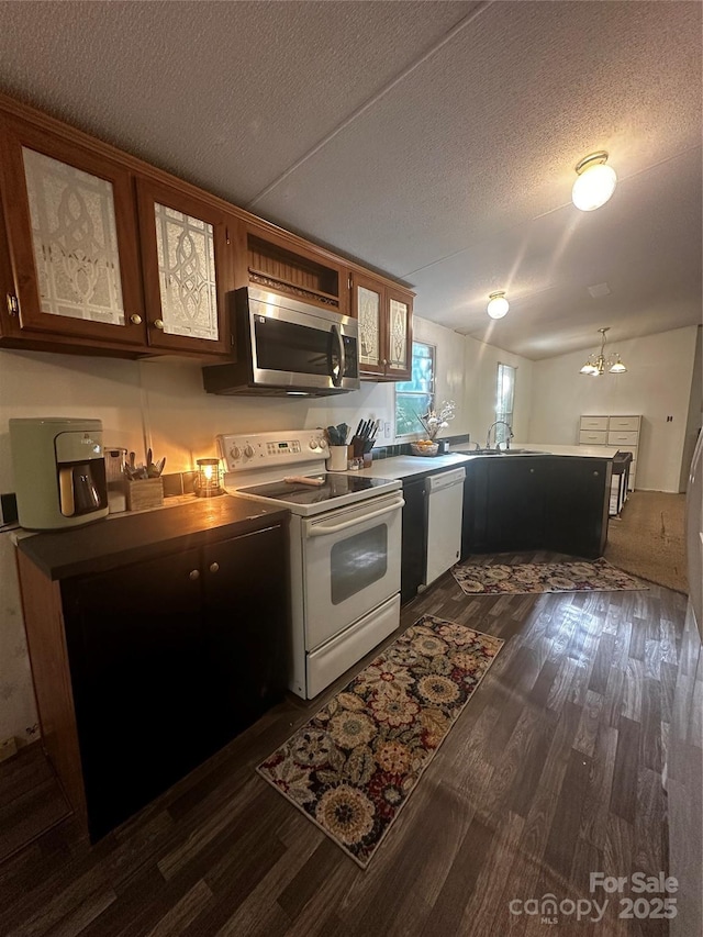 584 Ebenezer Rd, Old Fort, NC 28762 - kitchen with white appliances, a peninsula, dark wood-style floors, glass insert cabinets, and a textured ceiling