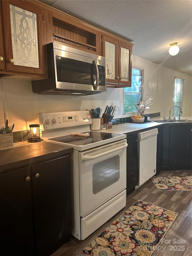 584 Ebenezer Rd, Old Fort, NC 28762 - kitchen featuring white appliances, dark wood-style flooring, a textured ceiling, glass insert cabinets, and a peninsula