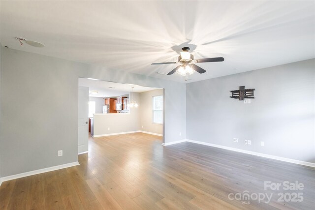 8225 Midas Ln, Locust, NC 28097 - unfurnished living room featuring ceiling fan, wood finished floors, and a chandelier