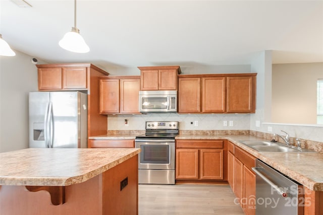8225 Midas Ln, Locust, NC 28097 - kitchen with stainless steel appliances, light wood-style flooring, light countertops, decorative backsplash, and decorative light fixtures