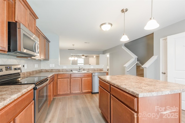 8225 Midas Ln, Locust, NC 28097 - kitchen with appliances with stainless steel finishes, light wood-style flooring, light countertops, and a center island