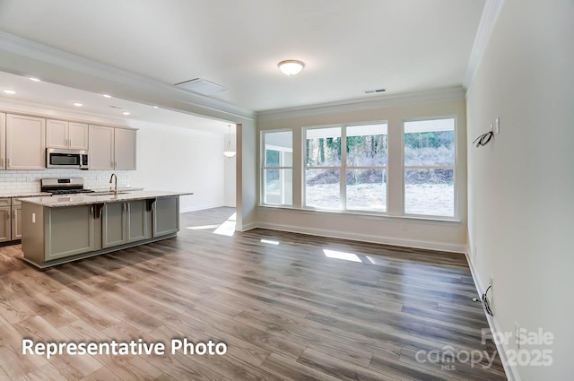 3238 Bozeman Ct Unit 07, Denver, NC 28164 - kitchen featuring stainless steel appliances, ornamental molding, gray cabinets, decorative backsplash, and wood finished floors