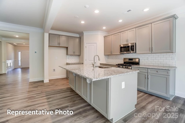 3238 Bozeman Ct Unit 07, Denver, NC 28164 - kitchen with stainless steel appliances, gray cabinets, crown molding, a center island with sink, and light wood-style floors