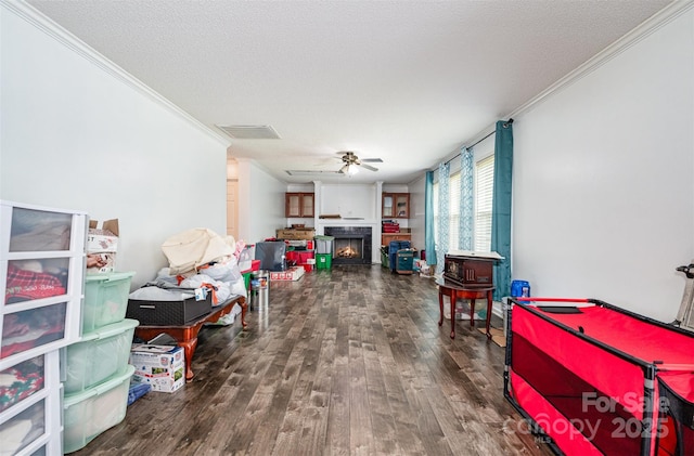 5602 Flint Ridge Church Rd, Marshville, NC 28103 - playroom featuring crown molding, wood finished floors, a lit fireplace, ceiling fan, and a textured ceiling