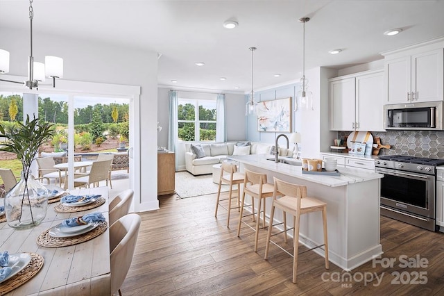 9312 Munsing Dr Unit 144, Charlotte, NC 28269 - kitchen with stainless steel appliances, dark wood-style floors, backsplash, light stone counters, and a breakfast bar area