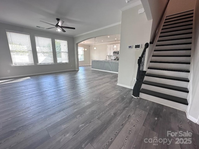 764 River Park Rd, Belmont, NC 28012 - unfurnished living room featuring crown molding, ceiling fan, stairs, dark wood-style floors, and arched walkways