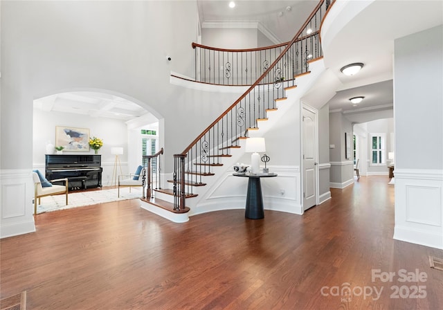 3015 Stanbury Dr, Matthews, NC 28104 - entrance foyer featuring wood finished floors, stairway, arched walkways, wainscoting, and a decorative wall
