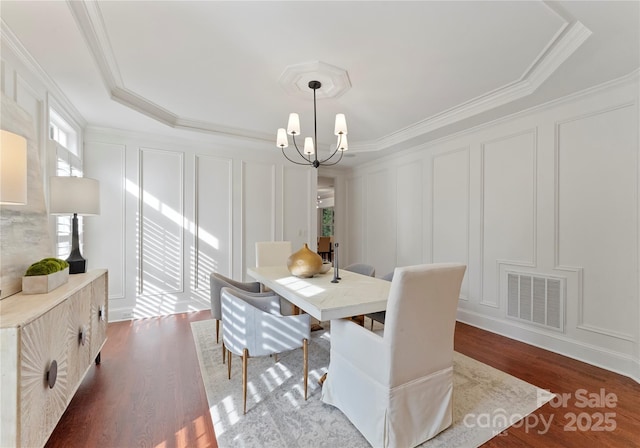 3015 Stanbury Dr, Matthews, NC 28104 - dining area with a decorative wall, dark wood-style flooring, crown molding, and a chandelier