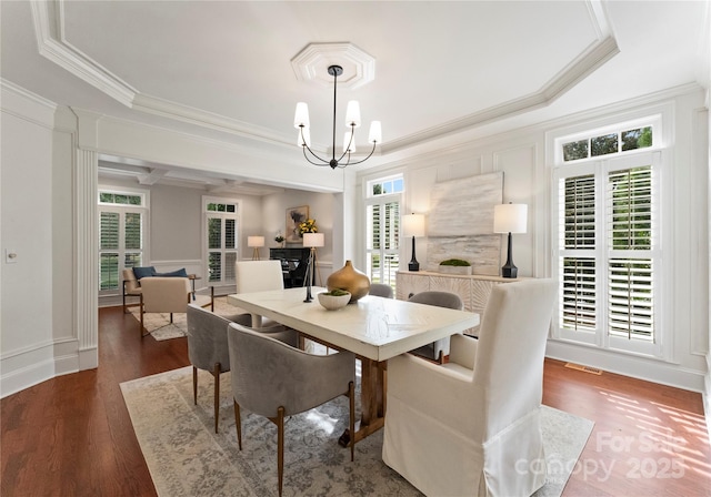 3015 Stanbury Dr, Matthews, NC 28104 - dining space featuring ornamental molding, a chandelier, wood finished floors, and a decorative wall