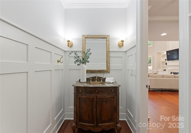 3015 Stanbury Dr, Matthews, NC 28104 - bathroom with a decorative wall, crown molding, vanity, wood finished floors, and a wainscoted wall