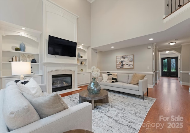3015 Stanbury Dr, Matthews, NC 28104 - living area with wood finished floors, built in shelves, a fireplace, recessed lighting, and crown molding
