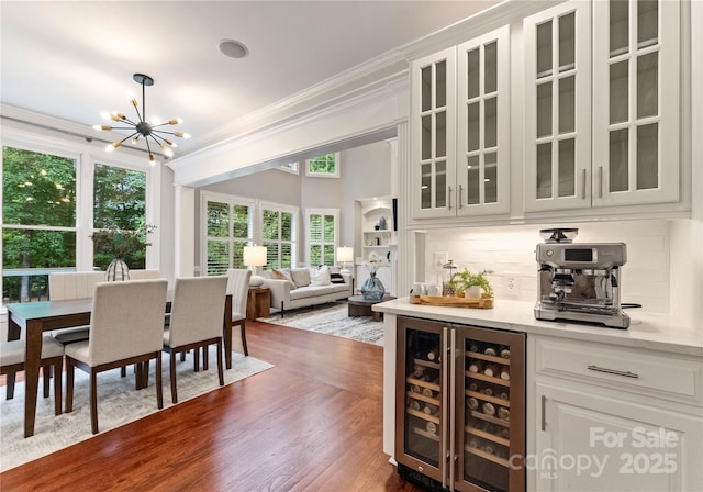 3015 Stanbury Dr, Matthews, NC 28104 - dining space with beverage cooler, crown molding, a chandelier, and dark wood-style floors
