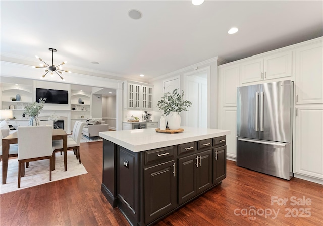 3015 Stanbury Dr, Matthews, NC 28104 - kitchen with stainless steel fridge, white cabinets, light countertops, a kitchen island, and crown molding