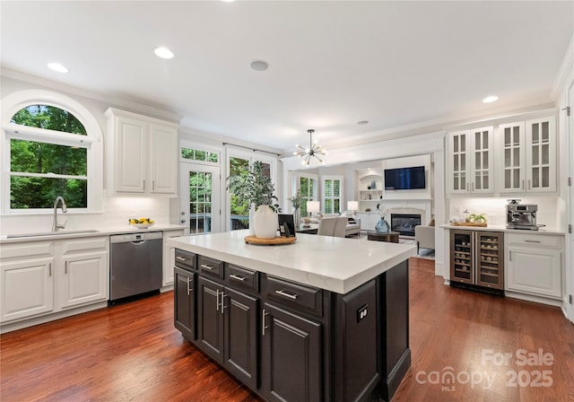 3015 Stanbury Dr, Matthews, NC 28104 - kitchen featuring stainless steel dishwasher, beverage cooler, white cabinets, ornamental molding, and light countertops