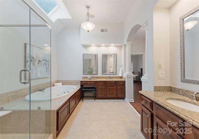 3015 Stanbury Dr, Matthews, NC 28104 - full bath featuring decorative columns, a stall shower, two vanities, a tub with jets, and tile patterned flooring