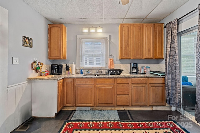74 Meadow Ave, Concord, NC 28025 - kitchen with a paneled ceiling, plenty of natural light, a wainscoted wall, and light stone counters
