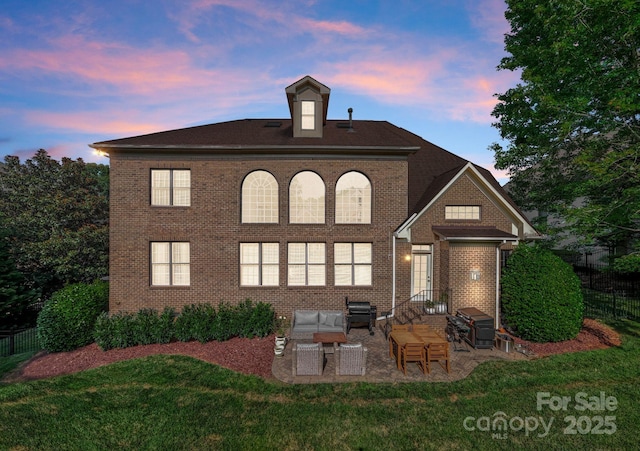 202 Montrose Dr, Waxhaw, NC 28173 - back of house at dusk with brick siding, a patio area, and outdoor lounge area