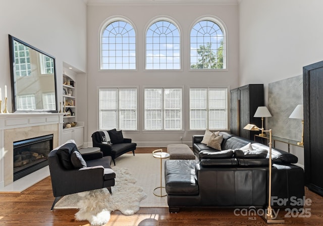 202 Montrose Dr, Waxhaw, NC 28173 - living area featuring a towering ceiling, wood finished floors, a tile fireplace, and ornamental molding