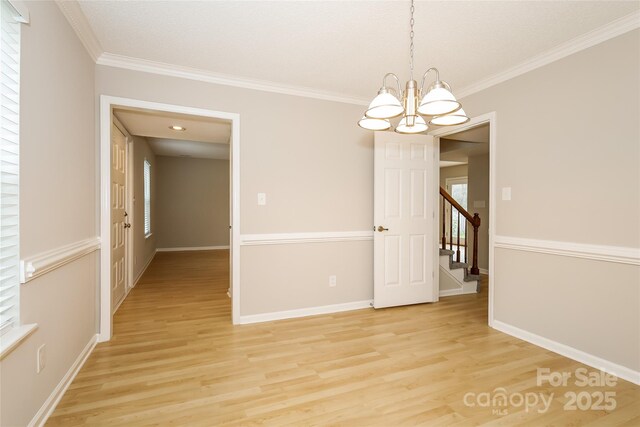 8749 Rittenhouse Cir, Charlotte, NC 28270 - spare room featuring a chandelier, light wood-style flooring, crown molding, and stairs