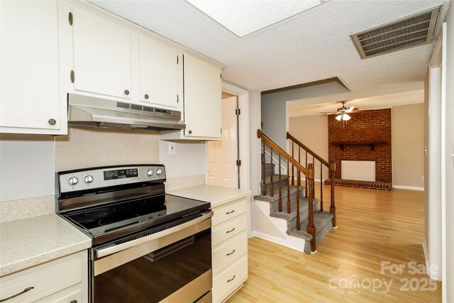 8749 Rittenhouse Cir, Charlotte, NC 28270 - kitchen featuring electric range, under cabinet range hood, light wood-style floors, light countertops, and a textured ceiling