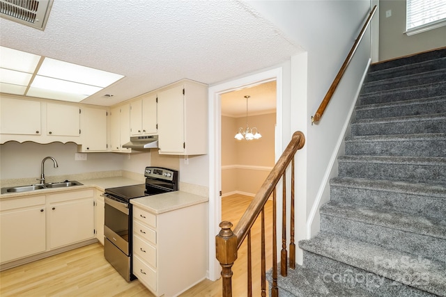 8749 Rittenhouse Cir, Charlotte, NC 28270 - kitchen with stainless steel electric range oven, light wood finished floors, under cabinet range hood, light countertops, and a chandelier