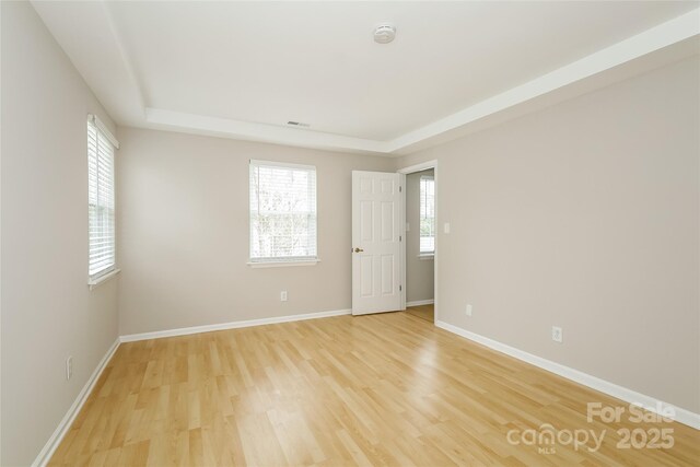 8749 Rittenhouse Cir, Charlotte, NC 28270 - empty room with a raised ceiling, light wood-style flooring, and a smoke detector