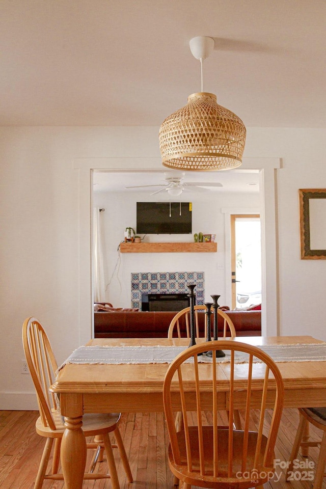 355 Walnut Ave, Spruce Pine, NC 28777 - dining area with light wood-type flooring, a stone fireplace, and ceiling fan