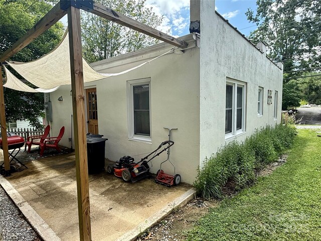 355 Walnut Ave, Spruce Pine, NC 28777 - rear view of property featuring stucco siding and a patio